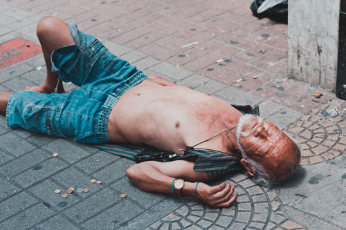 Pomoc osobie uzależnionej - alkoholik leżący na ulicy