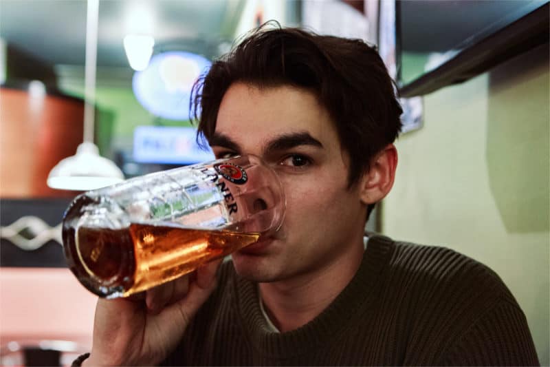 Mężczyzna pije piwo zastanawiając się kiedy zaczyna się problem z alkoholem w jego przypadku